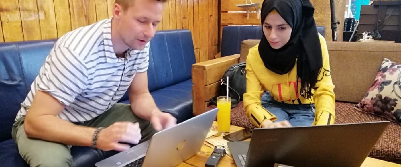 Andreas Hackl in conversation with a refugee AI worker at Taqadam