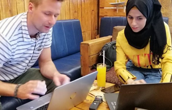 Andreas Hackl in conversation with a refugee AI worker at Taqadam